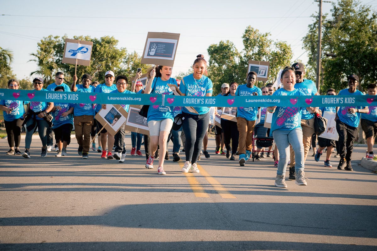 group of people crossing finish line at Walk in my shoes walk